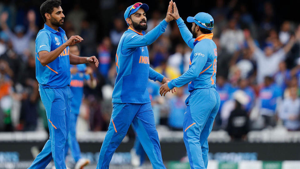 Virat Kohli celebrates with his players. (Photo by ADRIAN DENNIS/AFP/Getty Images)