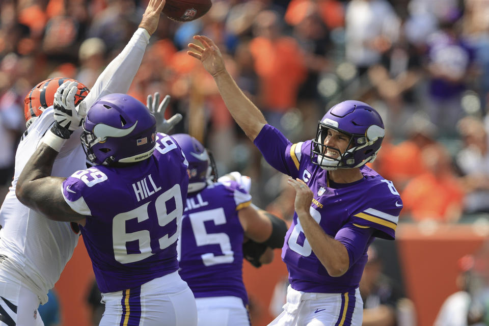 Minnesota Vikings quarterback Kirk Cousins (8) passes as Cincinnati Bengals defensive end Trey Hendrickson, left, pressures in the first half of an NFL football game, Sunday, Sept. 12, 2021, in Cincinnati. (AP Photo/Aaron Doster)