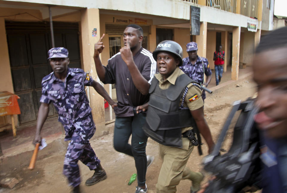 A supporter of pop star Kyagulanyi Ssentamu is detained following a demonstration in the Kamwokya area of Kampala, Uganda, Thursday, Aug. 16, 2018. Supporters were demonstrating in support of pop singer and prominent critic of Uganda's government Kyagulanyi Ssentamu, whose stage name is Bobi Wine, who was charged with unlawful possession of firearms and ammunition in a military court on Thursday for his alleged role in clashes in which the longtime president's motorcade was attacked by people throwing stones.(AP Photo/Stephen Wandera)