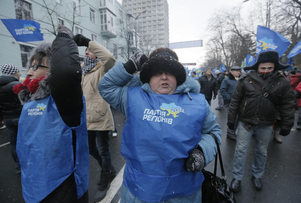 FILE - In this Sunday, Dec. 8, 2013 file photo Pro-Presidential supporters shout Anti-European Union slogans during a rally in Kiev, Ukraine. After two months of anti-government protests, modern Ukraine has never been so bitterly polarized. To be sure, Ukraine has long been divided. Russia and Europe have vied for dominance for centuries, causing deep cultural differences between the mostly Ukrainian-speaking western and central regions on the one hand, and the Russian-speaking east and south on the other. But as the crisis has deepened, each side has grown stronger in its convictions, and those who stood in the middle have been forced to choose sides. (AP Photo/Efrem Lukatsky, file)