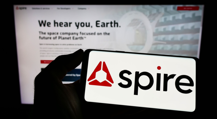 Person holding smartphone with logo of US data analytics company Spire Global Inc. (SPIR) on screen in front of website. Focus on phone display. Unmodified photo.