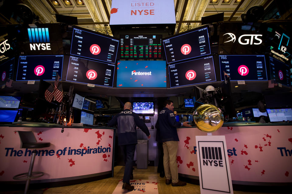Traders work beneath monitors displaying Pinterest Inc. signage during the company's initial public offering (IPO) on the floor of the New York Stock Exchange (NYSE) in New York, U.S., on Thursday, April 18, 2019. Pinterest's message to investors was don't compare us to social media or a search engine. The outcome Wednesday was that it raised about $1.4 billion in an above-range initial public offering. Photographer: Michael Nagle/Bloomberg via Getty Images
