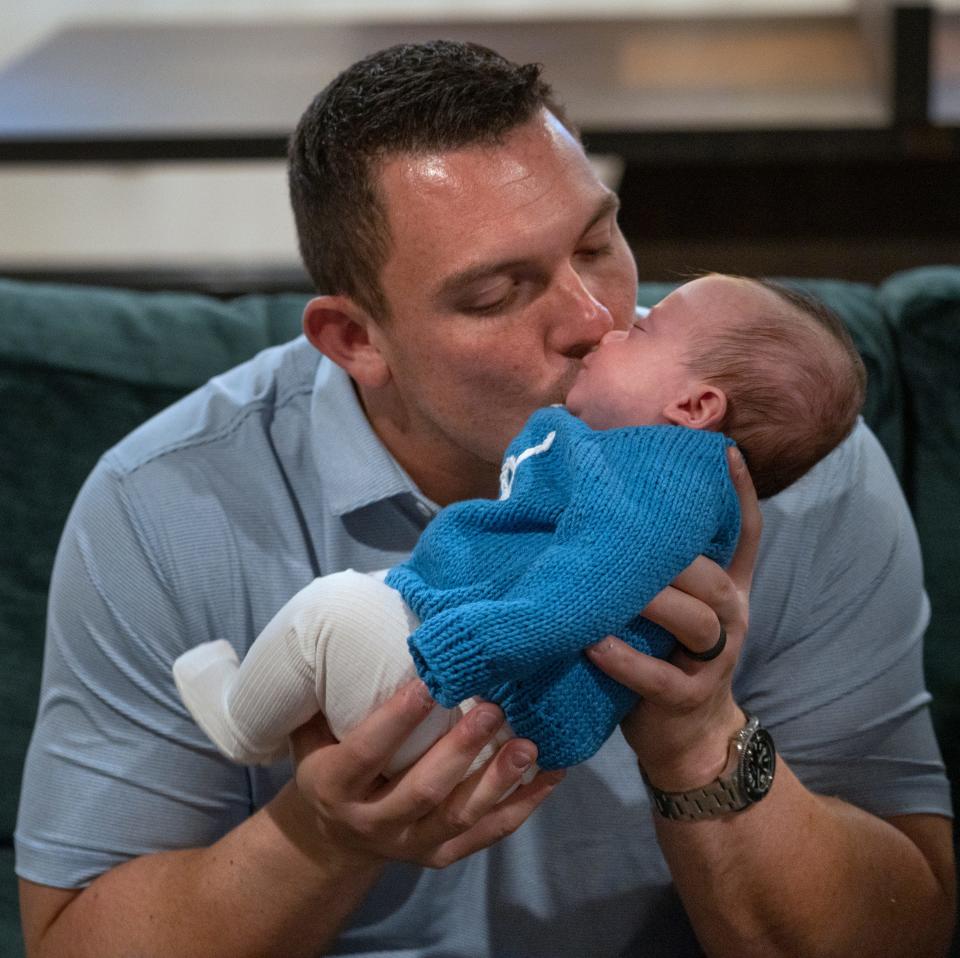 Indianapolis Colts Center Ryan Kelly kisses his new son, Ford, Thursday, Nov. 16, 2023 in their home. Emma says Ford looks exactly like Ryan and Duke looks like her family.