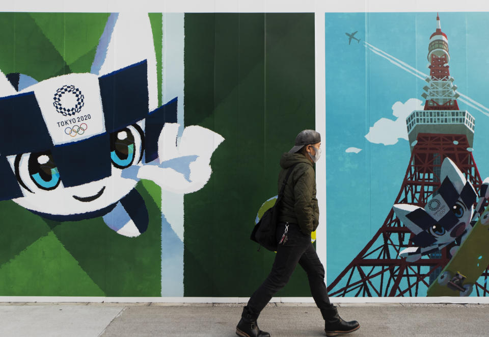 A man walks by posters to promote the Olympic and Paralympic games planned to start in the summer 2021, in Tokyo on Thursday, Nov. 12, 2020. The postponed Tokyo Olympics are to open in just under nine months. The International Olympic Committee and Japanese organizers have unwavering support from Japan’s ruling party and Tokyo’s municipal government. But there is a tiny murmur of resistance to the Olympic behemoth. A few voices in the national legislature question the wisdom of holding the Olympics in a pandemic. (AP Photo/Hiro Komae)