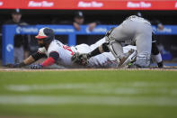 Minnesota Twins' Carlos Santana, left, beats the tag by Chicago White Sox catcher Korey Lee to score during the second inning of a baseball game Wednesday, April 24, 2024, in Minneapolis. (AP Photo/Abbie Parr)