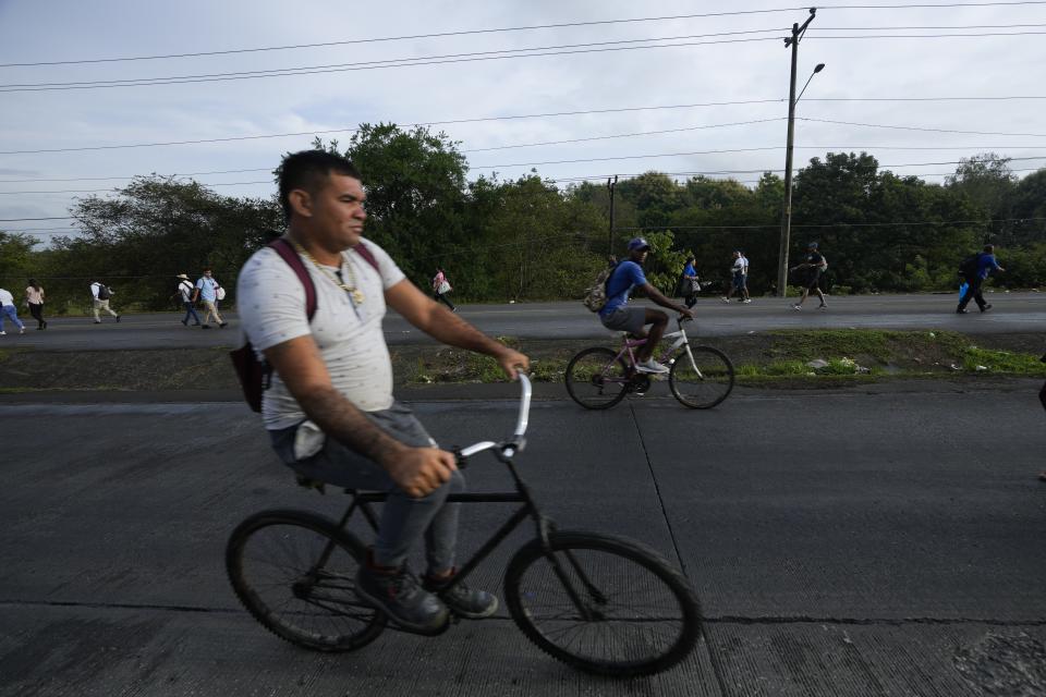 La gente anda en bicicleta y camina debido a los bloqueos de carreteras establecidos por los manifestantes que protestan contra la inflación, especialmente el aumento de los precios del combustible, en Pacora, Panamá, la madrugada del miércoles 20 de julio de 2022. (Foto AP/Arnulfo Franco)