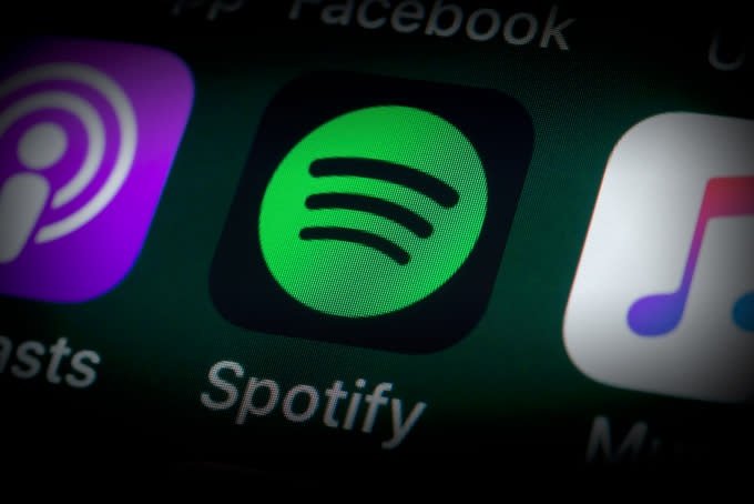 London, UK - July 31, 2018: The buttons of the music streaming app Spotify, surrounded by Podcasts, Apple Music, Facebook and other apps on the screen of an iPhone.