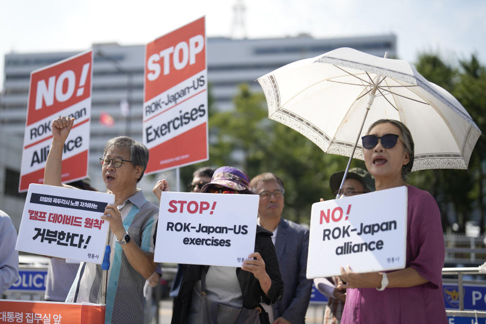 Protesters shout slogans during a rally in Seoul, South Korea, Thursday, Aug. 17, 2023, ahead of a trilateral summit between the U.S. President Joe Biden, South Korean President Yoon Suk Yeol and Japanese Prime Minister Fumio Kishida at Camp David in Maryland. The letters read, "Refuse, Camp David Principles." (AP Photo/Lee Jin-man)