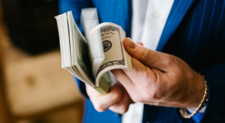 Man holding large wad of bills