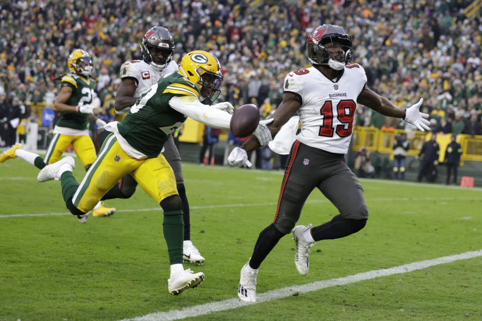 Tampa Bay Buccaneers wide receiver David Moore (19) scores on a 52-yard touchdown reception in front of Green Bay Packers safety Rudy Ford, left, during the second half of an NFL football game, Sunday, Dec. 17, 2023, in Green Bay, Wis. (AP Photo/Matt Ludtke)