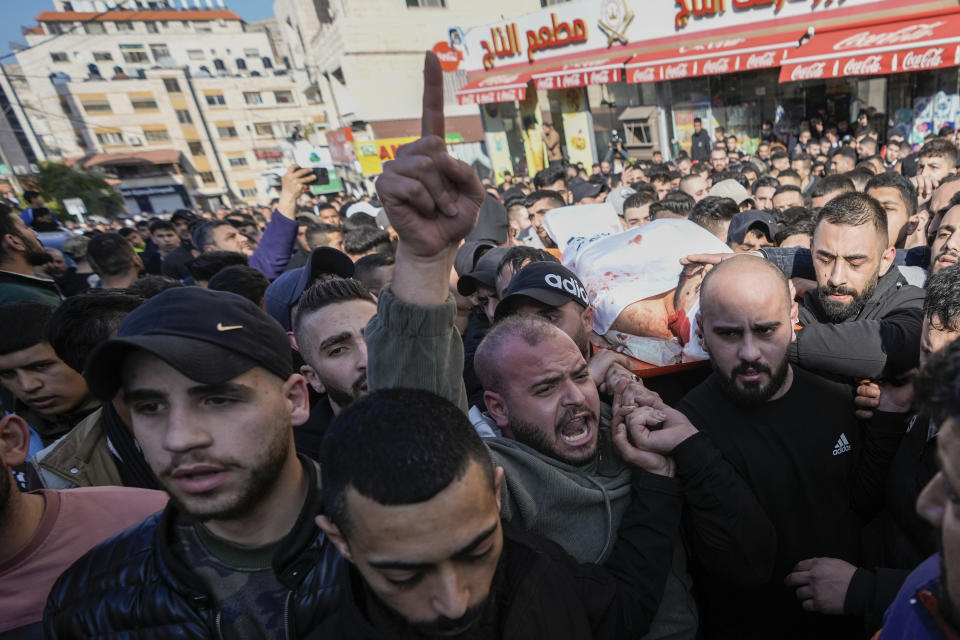 Palestinians carry the body of Hossam Selim after he was killed in clashes with Israel troops in the West Bank city of Nablus , Wednesday, Feb. 22, 2023. Israeli troops on Wednesday entered a major Palestinian city in the occupied West Bank in a rare, daytime arrest operation, triggering fighting that killed several Palestinians and wounded scores of others. (AP Photo/Majdi Mohammed)