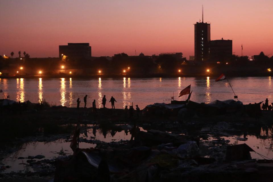 Protesters sit-in on the bank of Tigris River during ongoing protests in Baghdad, Iraq, Tuesday, Nov. 19, 2019. Anti-government protesters blocked access to a second major commercial port in southern Iraq on Tuesday, as bridge closures effectively split the capital in half, causing citizens to rely on boats for transport to reach the other side of the city. (AP Photo/Khalid Mohammed)