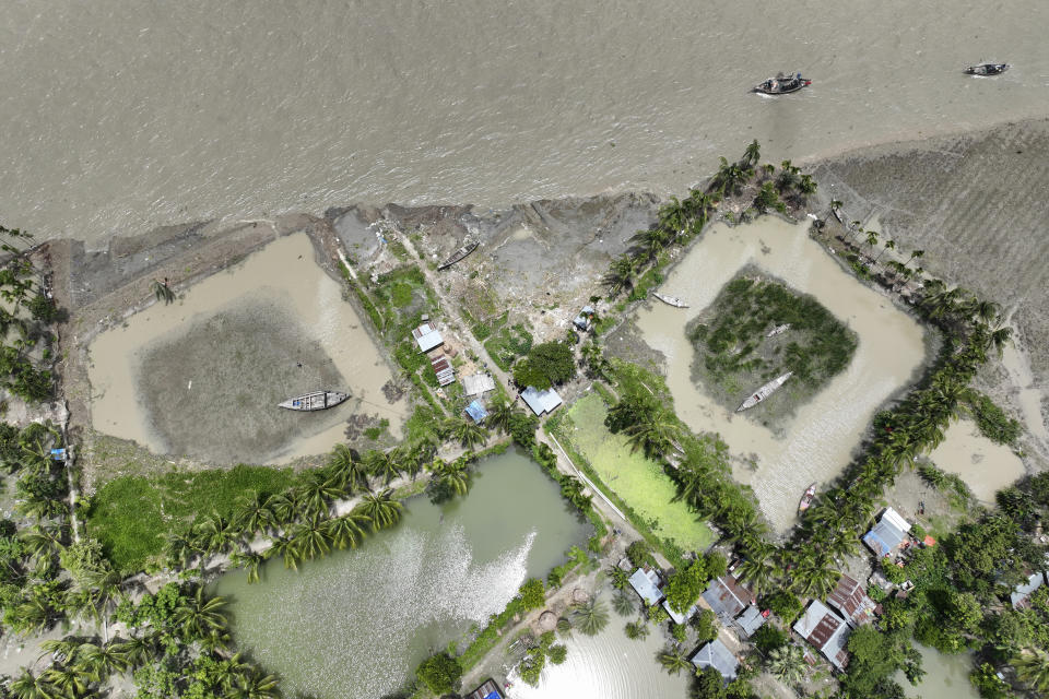 The embankment shows erosion caused by the Meghna River in the Ramdaspur village in the Bhola district of Bangladesh on July 5, 2022. Mohammad Jewel and Arzu Begum were forced to flee the area last year when the river flooded and destroyed their home. (AP Photo/Mahmud Hossain Opu)