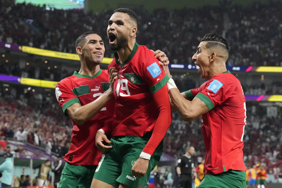 Morocco's Youssef En-Nesyri, center, celebrates after scoring his side's first goal during the World Cup quarterfinal soccer match between Morocco and Portugal, at Al Thumama Stadium in Doha, Qatar, Saturday, Dec. 10, 2022. (AP Photo/Martin Meissner)