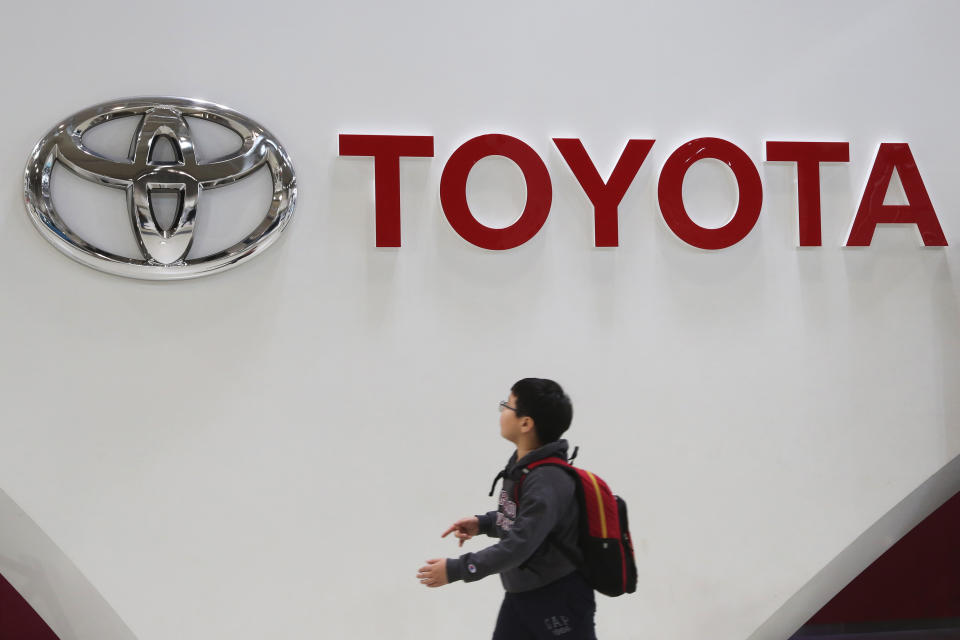 FILE - A boy looks at a logo of Toyota Motor Corp. at its gallery in Tokyo on Jan. 15, 2020. German truck maker Daimler, Japan’s top automaker Toyota and two other automakers said Tuesday, May 30, 2023, they will work together on new technologies, including use of hydrogen fuel, to help fight climate change. (AP Photo/Koji Sasahara, File)