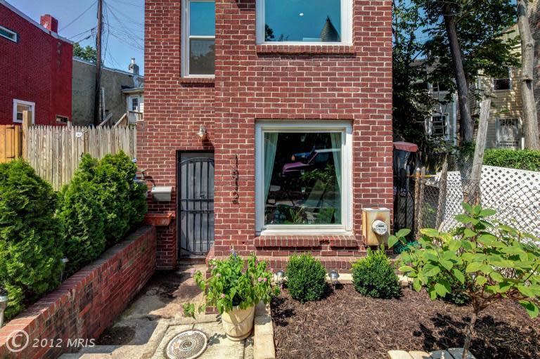 This is pretty much the extent of the "yard" for the house, but it's enough space for a sweet pocket garden for anyone with a green thumb. The plot hasn't been used to its full potential yet. Next photo: One exterior wall is coated in tar.