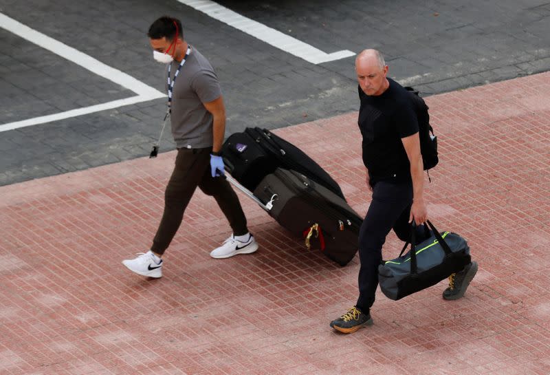 Tourists leave the hotel H10 Costa Adeje Palace, which is on lockdown after novel coronavirus has been confirmed in Adeje