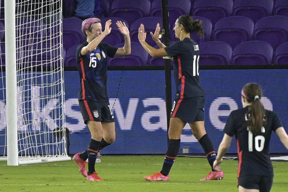 United States forward Megan Rapinoe (15) celebrates with forward Carli Lloyd (10) after Rapinoe score her second goal during the first half of a SheBelieves Cup women's soccer match against Argentina, Wednesday, Feb. 24, 2021, in Orlando, Fla. (AP Photo/Phelan M. Ebenhack)