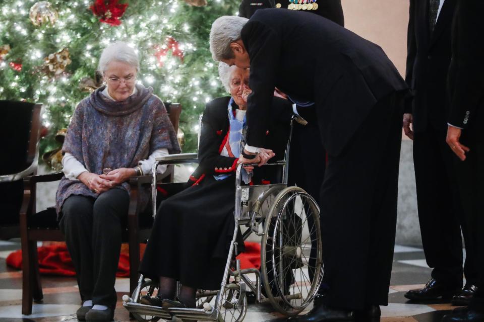 Annie Glenn holds the hand of U.S. Secretary of State John Kerry as her husband John Glenn lies in honor at the Ohio Statehouse rotunda, Friday, Dec. 16, 2016, in Columbus, Ohio. Glenn's home state and the nation began saying goodbye to the famed astronaut who died last week at the age of 95. (AP Photo/John Minchillo)