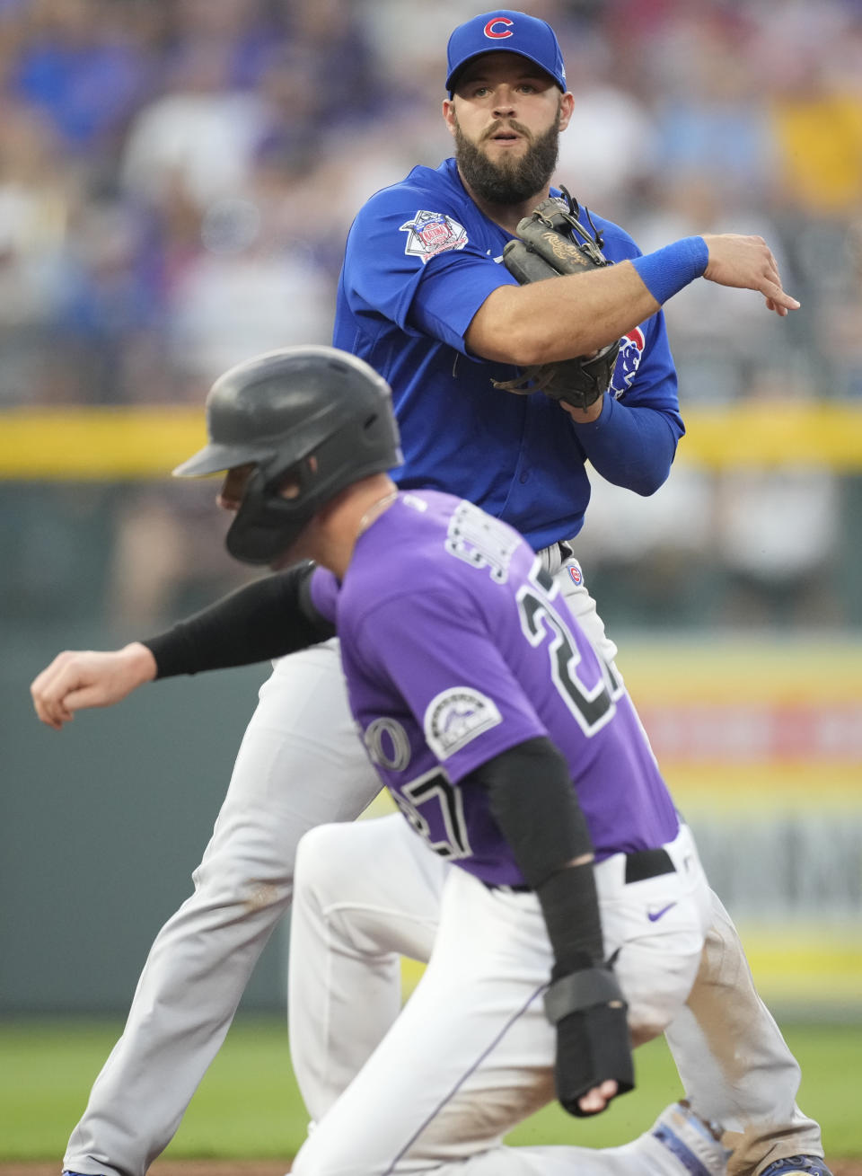 Chicago Cubs second baseman David Bote, back, forces out Colorado Rockies' Trevor Story at second base on the front end of a double play hit into by C.J. Cron to end the third inning of a baseball game Wednesday, Aug. 4, 2021, in Denver. (AP Photo/David Zalubowski)