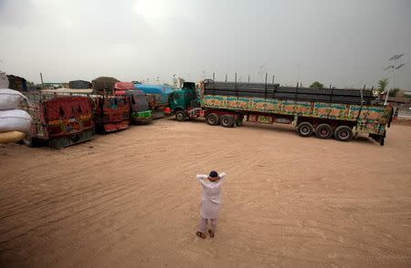 A driver reacts while looking at trucks carrying goods while waiting to cross into Afghanistan at a compound in Peshawar, Pakistan, June 15, 2016. REUTERS/Fayaz Aziz