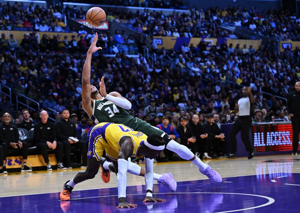 Bucks forward Giannis Antetokounmpo puts up a shot while getting fouled by Lakers guard Dennis Schroder after a drive to the bucket during the first quarter Thursday night in Los Angeles.