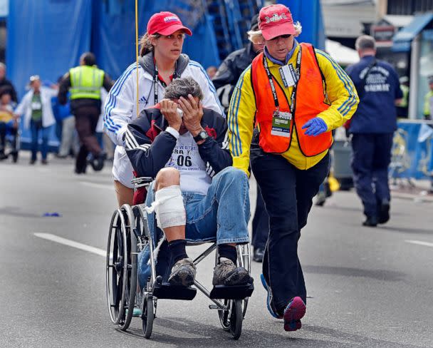 PHOTO: An injured man with his face in his hands is wheeled away from the aftermath of explosions at the finish line of the Boston Marathon, April 15, 2013. (MediaNews Group/Boston Herald via Getty Images)