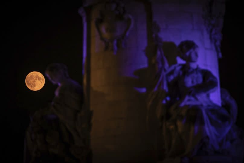 The supermoon appears behind the statue on Place de la République, Monday, Aug. 19, 2024, in Paris.