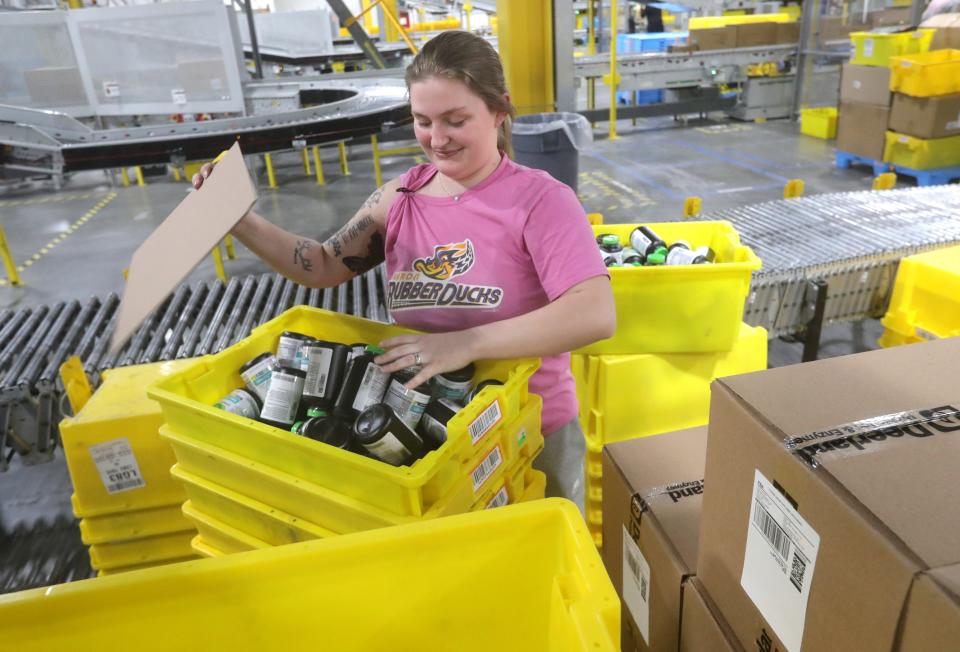 Akron Amazon Fulfillment Center inbound associate Kelsey Davis unpacks products as they arrive at the facility.