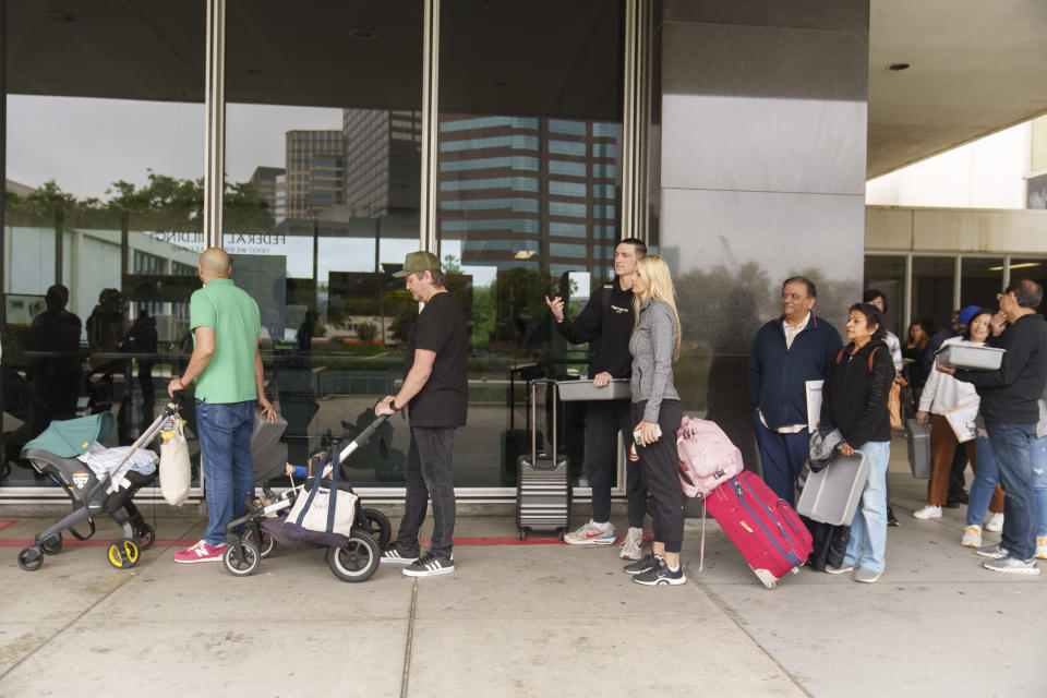 Marni Larsen and her son, Damon Rasmussen of Holladay, Utah, stand in line hoping to snag her son's passport outside the Los Angeles Passport Agency at the Federal Building in Los Angeles on Wednesday, June 14, 2023. Larsen applied for her son's passport two months earlier and spent weeks checking for updates online or through a frustrating call system. (AP Photo/Damian Dovarganes)