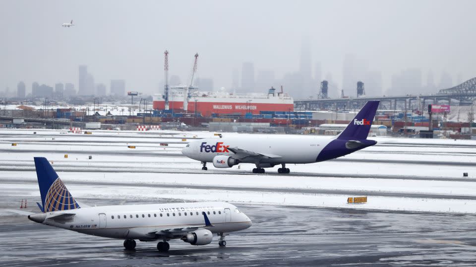 The Lower Manhattan skyline is partially obstructed by fog as planes taxi at Newark Liberty International Airport a day after a snowstorm hit the region. - Julio Cortez/AP