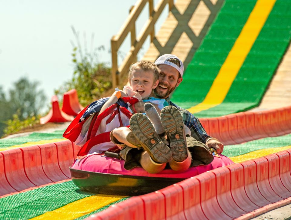 Ryan and Ethan Godwin take a spin on the inner tube hill slide during last year's Holland Farm Pumpkin Patch and Maze in Milton.