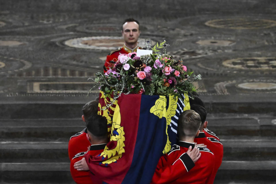 The Bearer Party of The Queen's Company, 1st Battalion Grenadier Guards carries the coffin of Queen Elizabeth II in Westminster Abbey in central London, Monday Sept. 19, 2022. The Queen, who died aged 96 on Sept. 8, will be buried at Windsor alongside her late husband, Prince Philip, who died last year. (Ben Stansall/Pool via AP)