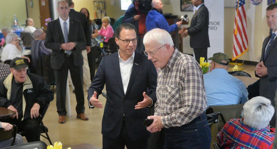 Pennsylvania Governor Josh Shapiro, center left, speaks with Tim Donlin, 76, during a visit to the Erie West Senior Center to discuss property tax and rent rebate programs for seniors on May 4, 2023. 