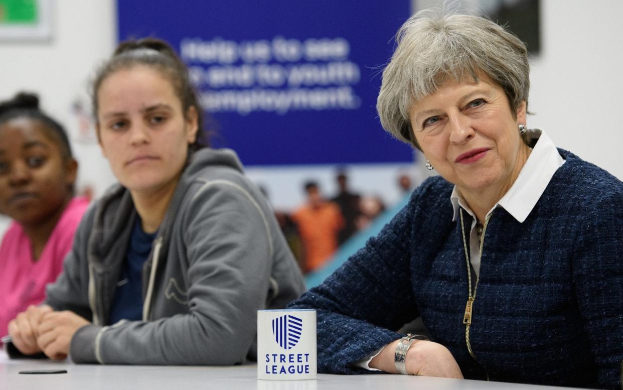 British Prime Minister Theresa May (R) listens as she meets young people at the