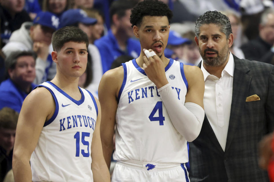 Kentucky's Reed Sheppard (15), Tre Mitchell (4) receive instructions from assistant coach Orlando Antigua, right, during the first half of an NCAA college basketball game against Mississippi Tuesday, Feb. 13, 2024, in Lexington, Ky. (AP Photo/James Crisp)