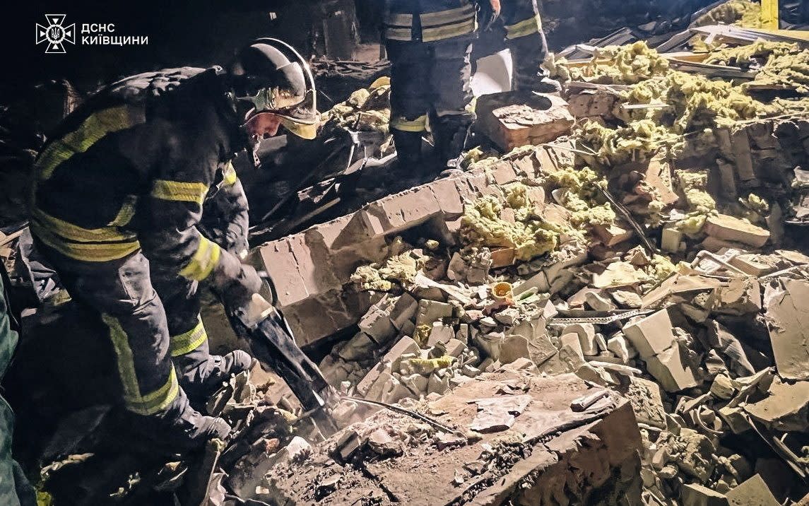 Rescuers work at a site where residential buildings were damaged during a Russian military strike in Brovary