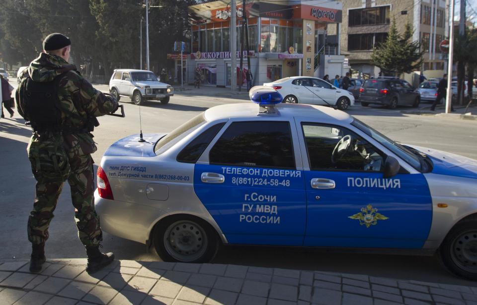 A Russian police officer stands on a street in Sochi December 30, 2013. The International Olympic Committee has no doubt Russian authorities will be able to provide security at the Winter Olympics, a spokeswoman said on Monday after two bomb blasts killed tens of people in the Russian city of Volgograd. REUTERS/Maxim Shemetov (RUSSIA - Tags: SPORT OLYMPICS CRIME LAW DISASTER)