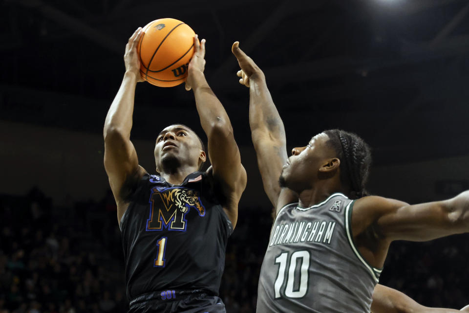 Memphis guard Jayhlon Young (1) shoots as UAB guard Alejandro Vasquez (10) defends during the first half of an NCAA college basketball game, Sunday, Jan. 28, 2024, in Birmingham, Ala. (AP Photo/ Butch Dill)
