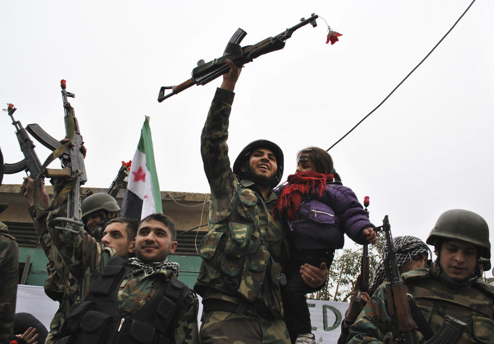 FILE - In this Thursday, Jan. 26, 201, file photo, Syrian army defectors, celebrate shortly after they defected and join the anti-Syrian regime protesters at Khaldiyeh area in Homs province, central Syria. Ten years ago, an uprising in Tunisia opened the way for a wave of popular revolts against authoritarian rulers across the Middle East known as the Arab Spring. For a brief window as leaders fell, it seemed the move toward greater democracy was irreversible. Instead, the region saw its most destructive decade of the modern era. Syria, Yemen, Libya and Iraq have been torn apart by wars, displacement and humanitarian crisis. (AP Photo, File)