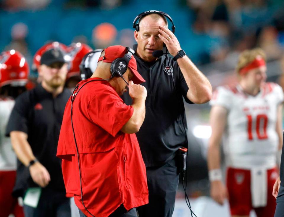 N.C. State head coach Dave Doeren talks with defensive coordinator Tony Gibson during the second half of Miami’s 31-30 victory over N.C. State at Hard Rock Stadium in Miami Gardens, Fla. Saturday, Oct. 23, 2021.