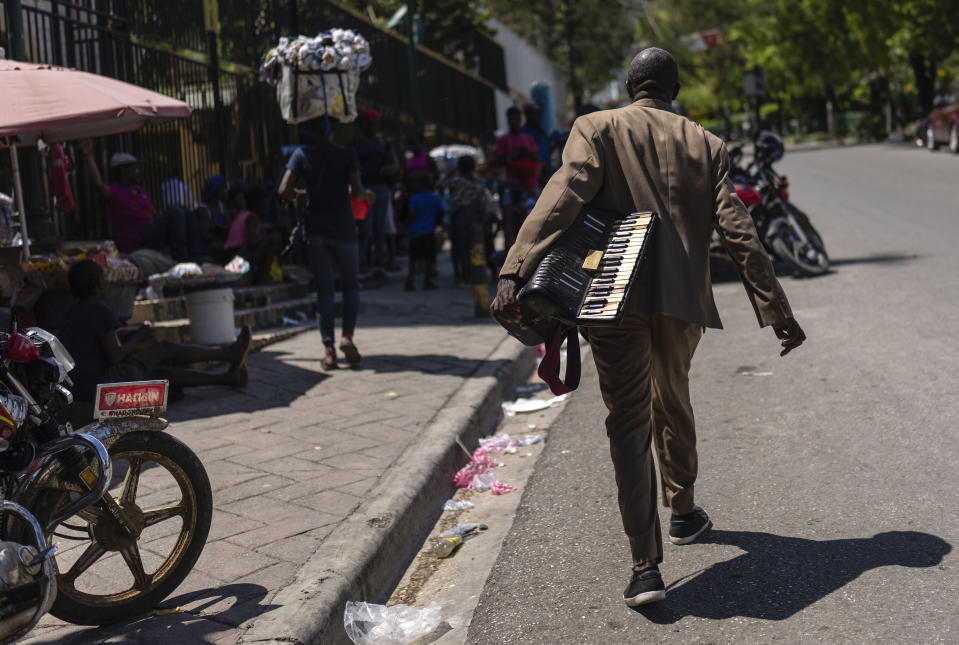 A man carries an accordion in Port-au-Prince, Haiti, April 28, 2024. (AP Photo/Ramon Espinosa)