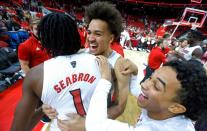 N.C. State’s Jericole Hellems (4) and Chase Graham (12), right, celebrate with Dereon Seabron (1) after N.C. State’s 104-100 victory over Nebraska in four overtimes at PNC Arena in Raleigh, N.C., Wednesday, December 1, 2021.