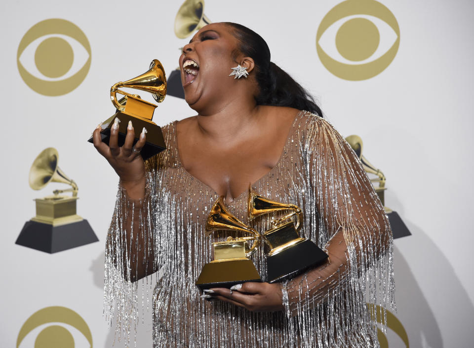 Lizzo poses in the press room with the awards for best pop solo performance for "Truth Hurts", best urban contemporary album for "Cuz I Love You" and best traditional R&B performance for "Jerome" at the 62nd annual Grammy Awards at the Staples Center on Sunday, Jan. 26, 2020, in Los Angeles. (AP Photo/Chris Pizzello)