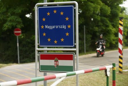 A motorcyclist passes the border between Austria and Hungary near St. Margarethen, Austria, June 24, 2015. REUTERS/Heinz-Peter Bader