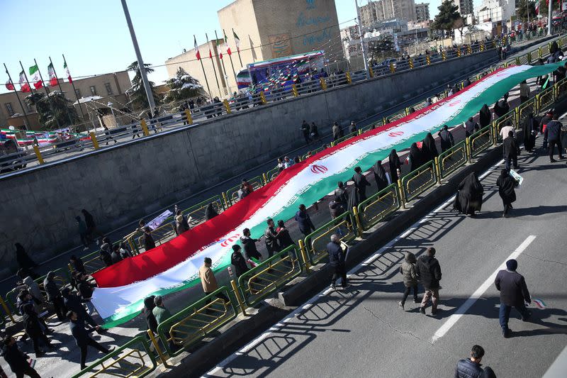 Iranians carry the Iranian flag as they gahter during the commemoration of the 41st anniversary of the Islamic revolution in Tehran