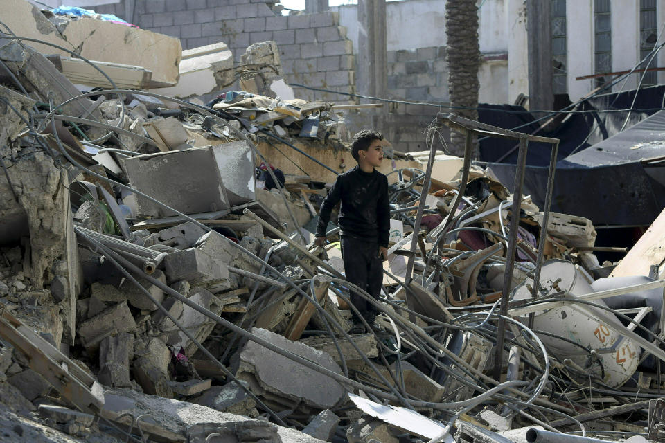 Un niño palestino busca pertenencias familiares entre escombros de instalaciones destruidas cerca de un edificio de seguridad de Hamas que fue destruido el lunes durante un ataque aéreo israelí, el miércoles 27 de marzo del 2019 en Ciudad de Gaza. (AP Foto/Adel Hana)