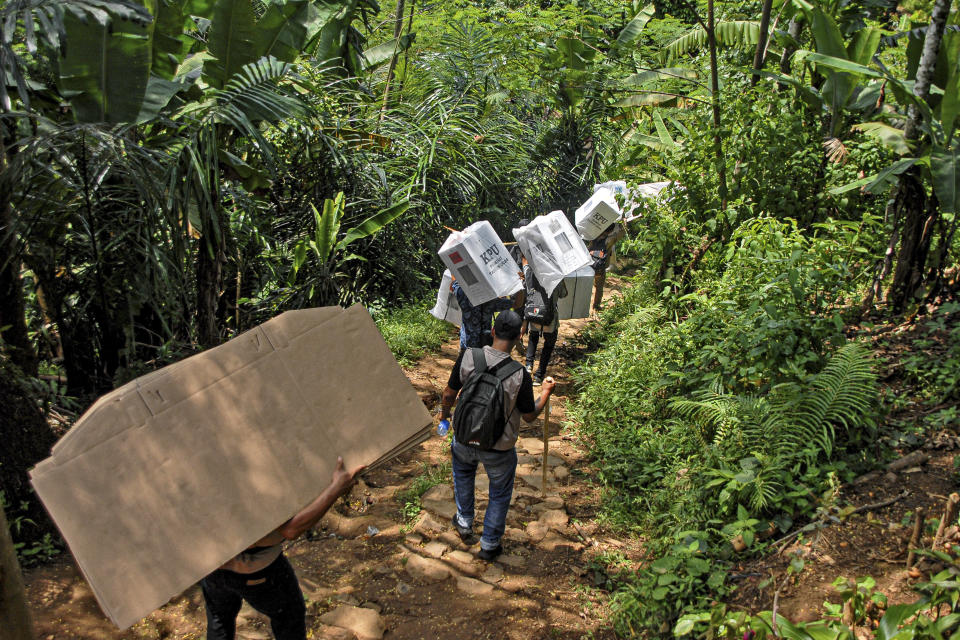 People carry ballot boxes to be distributed to polling stations ahead of the Feb. 14 election, in Kanekes village, Indonesia, Tuesday, Feb. 13, 2024. Indonesia, the world's third-largest democracy, will open its polls on Wednesday to nearly 205 million eligible voters in presidential and legislative elections, the fifth since Southeast Asia's largest economy began democratic reforms in 1998. (AP Photo/Rangga Firmansyah)