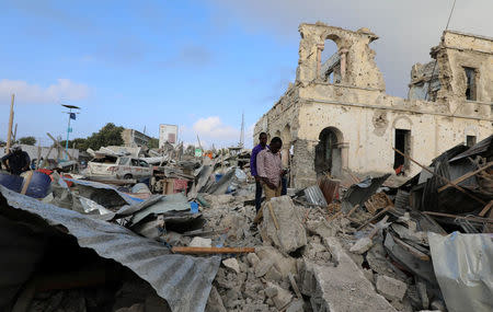 Civilians look at the scene after a suicide car explosion in front of Doorbin hotel in Mogadishu, Somalia February 24, 2018. REUTERS/Feisal Omar