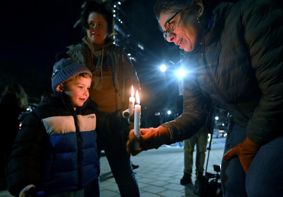 Bixby Fiske, 3, has his candle relit by Maya Desai as his mother, Jenny Pacillo, looks on behind him during a candlelight vigil Monday in memory of Tyre Nichols outside Worcester City Hall.